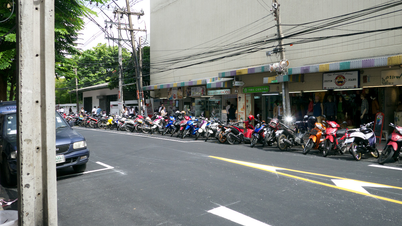 Pavement crammed with motorcycles on a side street in Bankok